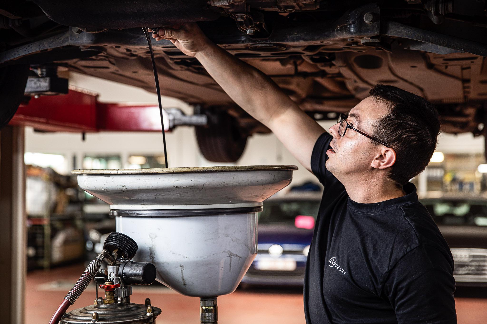Onderhoudstechnicus die de olie van een wagen vervangt